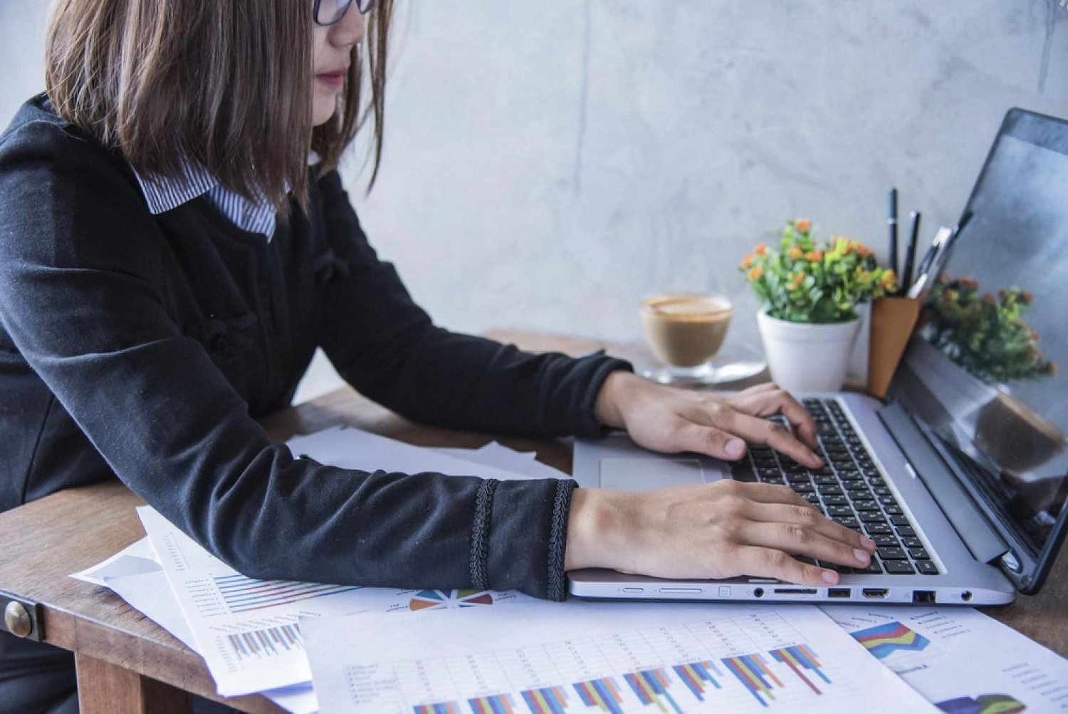 Hotel manager reviewing PMS reports and occupancy charts on a laptop