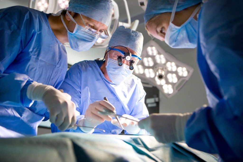 Surgical team performing a gallbladder operation under operating theatre lights